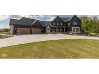Stunning two-story home with a dark exterior, three-car garage, and professionally landscaped front yard at 4078 Besbie Way, Bargersville, IN 46106