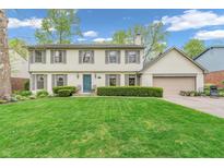 Charming two-story home with a well-manicured lawn and a beautiful blue front door at 4232 Briarwood Dr, Indianapolis, IN 46250