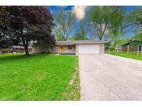 Charming single-story home with stone facade, attached garage, bright yellow door, and well-maintained lawn at 444 Buffalo Dr, Indianapolis, IN 46217