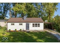 Charming single-story home with a well-maintained lawn and a convenient carport on a sunny day at 4716 E 33Rd St, Indianapolis, IN 46218