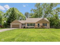 Charming single-story home with a manicured lawn, lovely front porch, and attached garage, perfect for suburban living at 5015 E 70Th E St, Indianapolis, IN 46220