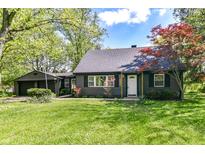 Charming home with a well-manicured lawn, dark siding, and mature trees creating a welcoming curb appeal at 5721 Daphne Dr, Indianapolis, IN 46278