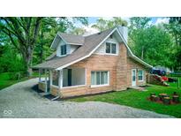 Charming stone two-story home with a gravel driveway and covered porch at 5811 King Ave, Indianapolis, IN 46228