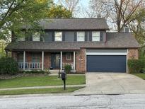 Charming two-story home with brick accents, a covered porch, and well-maintained landscaping at 8507 Promontory Rd, Indianapolis, IN 46236