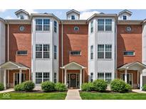 Charming townhome with brick facade, complemented by manicured landscaping and a welcoming front entrance at 863 N Park Trail Dr, Carmel, IN 46032