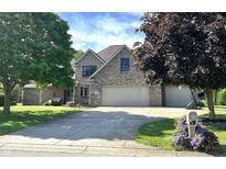 Charming two-story brick home featuring an attached two-car garage and a well-maintained lawn at 941 W Barouche, Pendleton, IN 46064