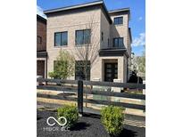 Modern brick home featuring a well-manicured yard and black fence at 11904 Spring Mill Rd, Carmel, IN 46032