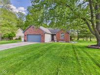 Charming brick home featuring a well-manicured lawn and attached two-car garage at 1356 S Catamaran Cir, Cicero, IN 46034