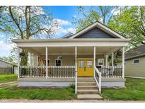 Charming home featuring a welcoming front porch with black railing and bright yellow front door at 1421 Laurel St, Indianapolis, IN 46203