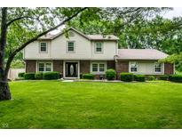Traditional two-story home boasts a lush green lawn, mature trees and manicured bushes at 15203 Shoreway Ct, Carmel, IN 46032