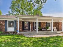 Charming brick home with a welcoming covered front porch and comfortable seating area at 1813 Kingsley Dr, Anderson, IN 46011