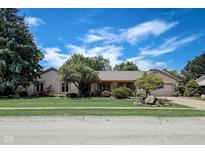 Charming ranch home featuring a manicured lawn, mature trees, and brick facade, set under a bright blue sky at 2204 Center Dr, Lebanon, IN 46052