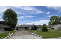Charming one-story home featuring a well-maintained lawn and a long driveway at 2927 E 8Th St, Anderson, IN 46012