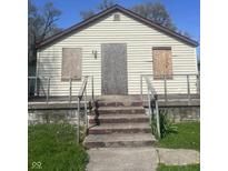 An exterior shot of a house with boarded up windows on a sunny day at 3242 Collier St, Indianapolis, IN 46221