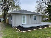 Charming single-story home with a freshly painted gray exterior, well-manicured yard and inviting front porch at 3411 Chase St, Indianapolis, IN 46217