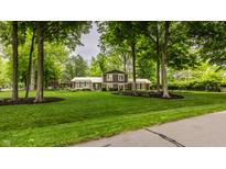 Charming two-story home with well-manicured lawn and mature trees at 411 Woodland W Dr, Greenfield, IN 46140