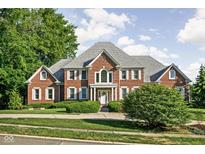 Stunning two-story brick home featuring a symmetrical design, well-manicured lawn, and mature trees at 4956 Waterside Cir, Carmel, IN 46033