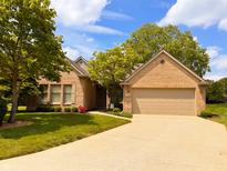 Charming brick home featuring a well-manicured lawn, beautiful trees, and a spacious two-car garage at 5190 Pursel Ln, Carmel, IN 46033