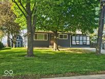 Charming home with well-maintained lawn, mature trees, and sun room at 706 Alexander St, Greenwood, IN 46143