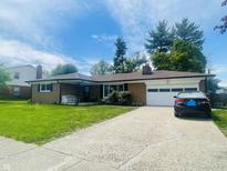 Charming single-story home featuring a brick facade, a well-manicured lawn, and an attached garage at 7844 Partridge Rd, Southport, IN 46227