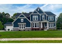 Beautiful two-story home featuring stone accents, a well-manicured lawn, and a classic blue facade at 1050 Windsor Estates Ct, Westfield, IN 46074