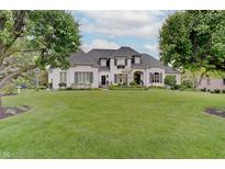 Stunning white home with lush green lawn, mature trees, and manicured landscaping creates idyllic curb appeal at 11508 Willow Ridge Dr, Zionsville, IN 46077