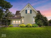 Charming home featuring a well-manicured lawn and delightful landscaping at dusk at 116 E Railroad St, Fountaintown, IN 46130