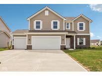 Charming two-story home features white-trimmed windows, a three-car garage, and a concrete driveway at 1614 N Clearwater Dr, Greenfield, IN 46140