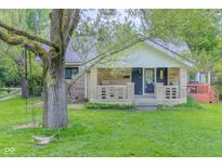 Charming single-story home with stone accents, covered porch and a swing hanging from a mature tree at 1709 E Loretta Dr, Indianapolis, IN 46227