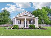 Charming home featuring a cozy front porch with a white picket fence and neatly landscaped yard at 2025 E Broadway St, Fortville, IN 46040