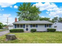 Charming single story home with manicured lawn, shutters, and a brick chimney under a beautiful blue sky at 2726 Dawson St, Indianapolis, IN 46203