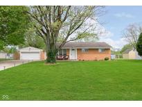 Charming brick ranch home featuring a well-maintained lawn and detached garage at 3723 S Dearborn St, Indianapolis, IN 46237