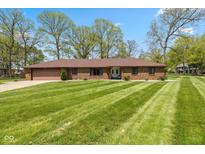 Charming ranch-style home with a manicured lawn, mature trees and attached two-car garage at 5312 Larita Ln, Anderson, IN 46017