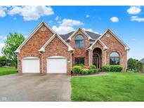 Charming two-story brick home with manicured lawn, three-car garage, and inviting curb appeal at 5377 Crooked Stick Ct, Greenwood, IN 46142