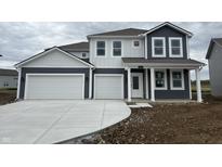 Striking two-story home boasting a three-car garage and modern design with dark gray and white accents at 5540 Tart Blvd, Indianapolis, IN 46239