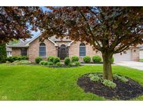 Charming brick home featuring a well-manicured lawn and mature trees in a desirable neighborhood at 5601 W Sun Point Dr, Muncie, IN 47304