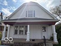 Traditional home featuring a quaint porch with decorative columns, windows, and fresh exterior paint at 616 N Exeter Ave, Indianapolis, IN 46222