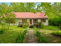 Charming single-story home with a red metal roof, stone path and a well-kept lawn at 680 Unity Church Rd, Morgantown, IN 46160