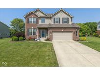 Charming two-story brick home with well-maintained landscaping and a two-car attached garage at 7140 Lakeland Trails Blvd, Indianapolis, IN 46259