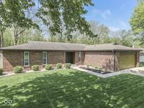 Charming single-story brick home with a well-manicured lawn and mature trees offering great curb appeal at 748 Woodcreek Ct, Greenwood, IN 46142