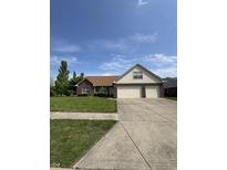 Charming brick home with a well-manicured lawn and a two-car garage on a sunny day at 8306 Hunters Meadow Way, Indianapolis, IN 46259