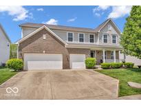 Beautiful two-story home featuring a brick facade, attached two-car garage, manicured lawn and charming front porch at 9712 Brooks Dr, McCordsville, IN 46055