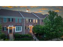 Charming brick townhome with manicured landscaping, covered entry, and welcoming front door at 13094 Overview Dr # 5D, Fishers, IN 46037