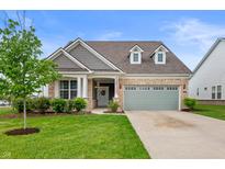 Charming home featuring brick and siding, a well-manicured lawn, and a sage green two-car garage at 16270 Northwind Ct, Westfield, IN 46074