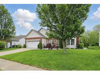 Charming brick and siding home features a well-manicured lawn and a two-car garage at 1663 Sweetgum Dr, Greenwood, IN 46143