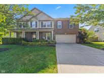 Charming two-story home featuring a brick facade, well-manicured lawn, and a two-car garage at 1783 Trillium Ct, Avon, IN 46123