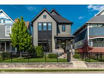 Charming two-story home with black trim, landscaped yard, and an inviting front porch at 2036 Central Ave, Indianapolis, IN 46202