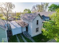 Two-story home featuring a gray exterior, metal roofed garage, and mature trees at 2221 Station St, Indianapolis, IN 46218