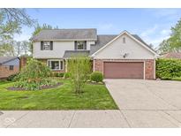 Charming two-story home with landscaped yard, brick accents, and a two-car garage at 320 Thornberry Dr, Carmel, IN 46032
