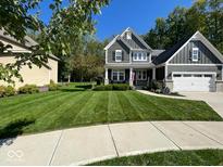 Charming two-story home with a well-manicured lawn and beautiful landscaping at 3243 Red Fox Trl, Columbus, IN 47201